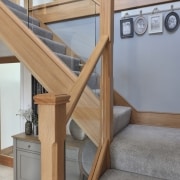 carpeted stairs with wooden glass railings