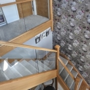 carpeted stairs with wooden glass railings