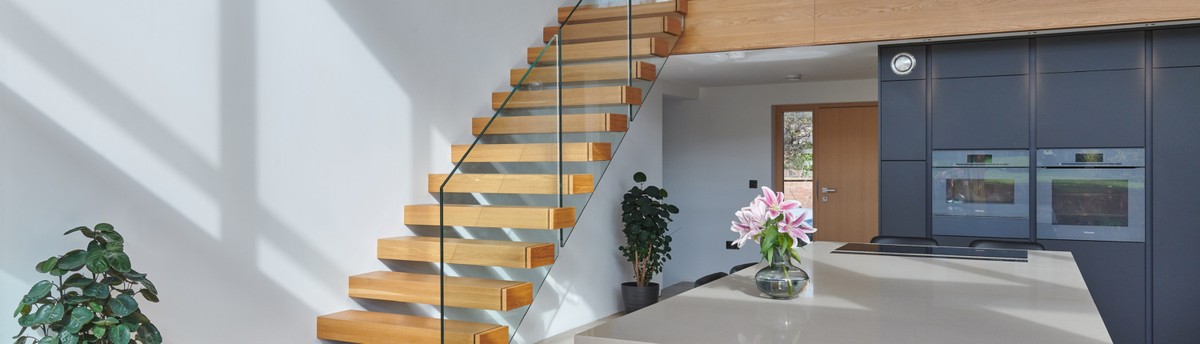 jarrods_nelms2256 (1) Modern interior with wooden stairs and plants.