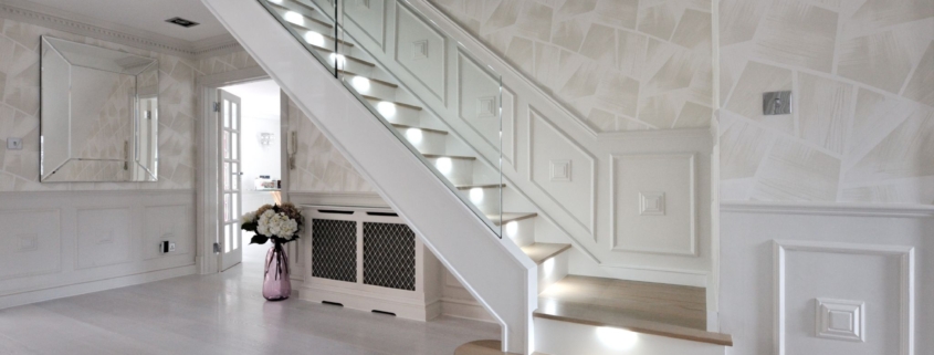 modern glass staircase in a spacious room with white walls and wooden accents